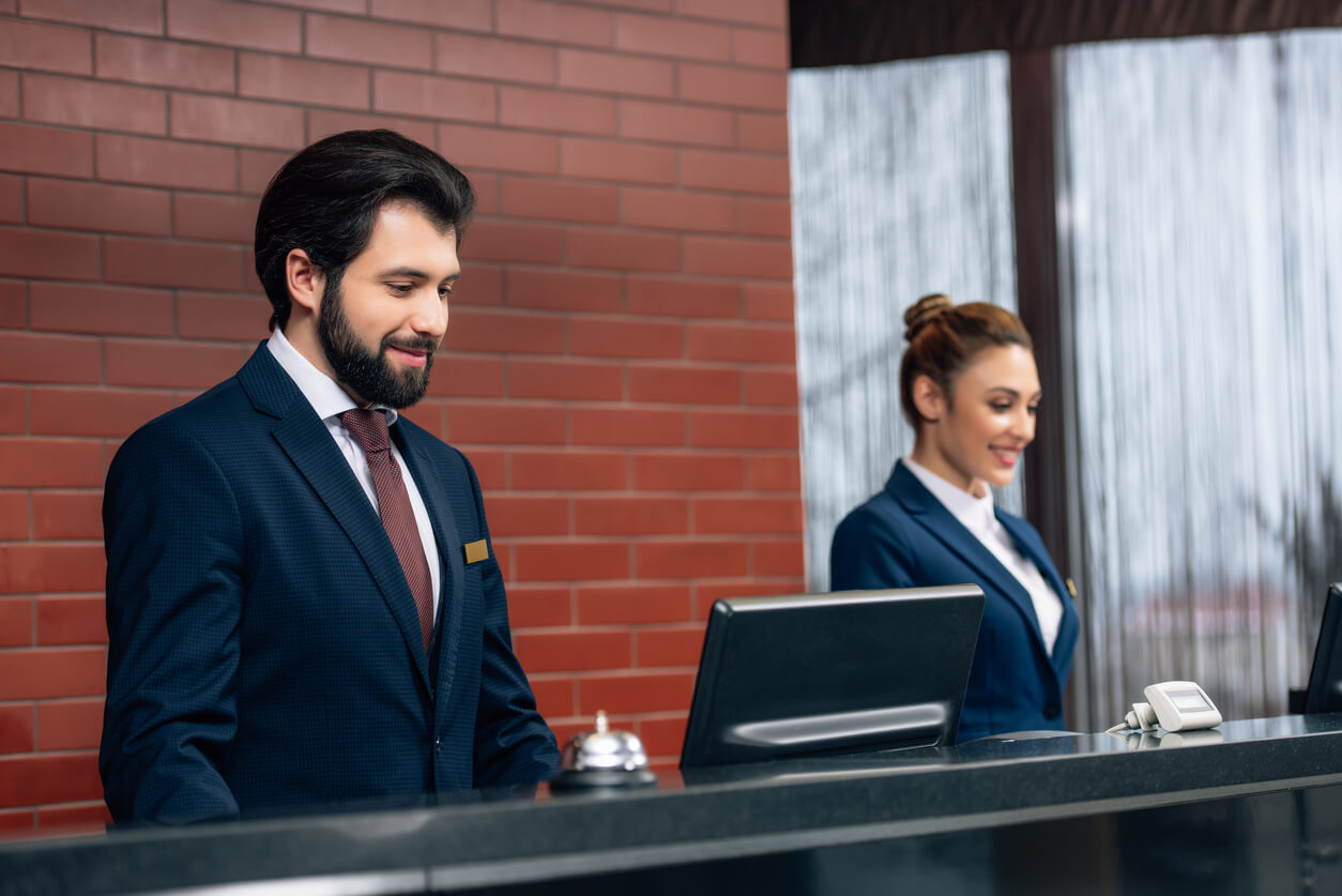 Hotel staff checking a guest's ID at the front desk